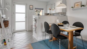A modern kitchen with a dining area, white cabinetry, and a blue rug. - "Enwald" - 100m from the sea by Interhome (Hals)