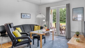 A modern living room with a sofa, chairs, a table, and a dining area. - "Enwald" - 100m from the sea by Interhome (Hals)
