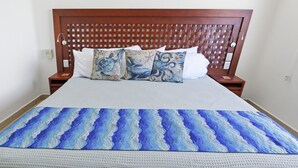 Een bed met een beddegoed met dessin en twee kussens met een zeeschildpaddenprint.