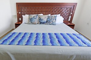 Ein Bett mit einem gemusterten Bettbezug und zwei Kissen mit einem Meeresschildkröten-Motiv.