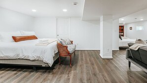 A modern bedroom with a bed, a chair, and a sofa. - Cavalier Cocoon (Charlottesville)