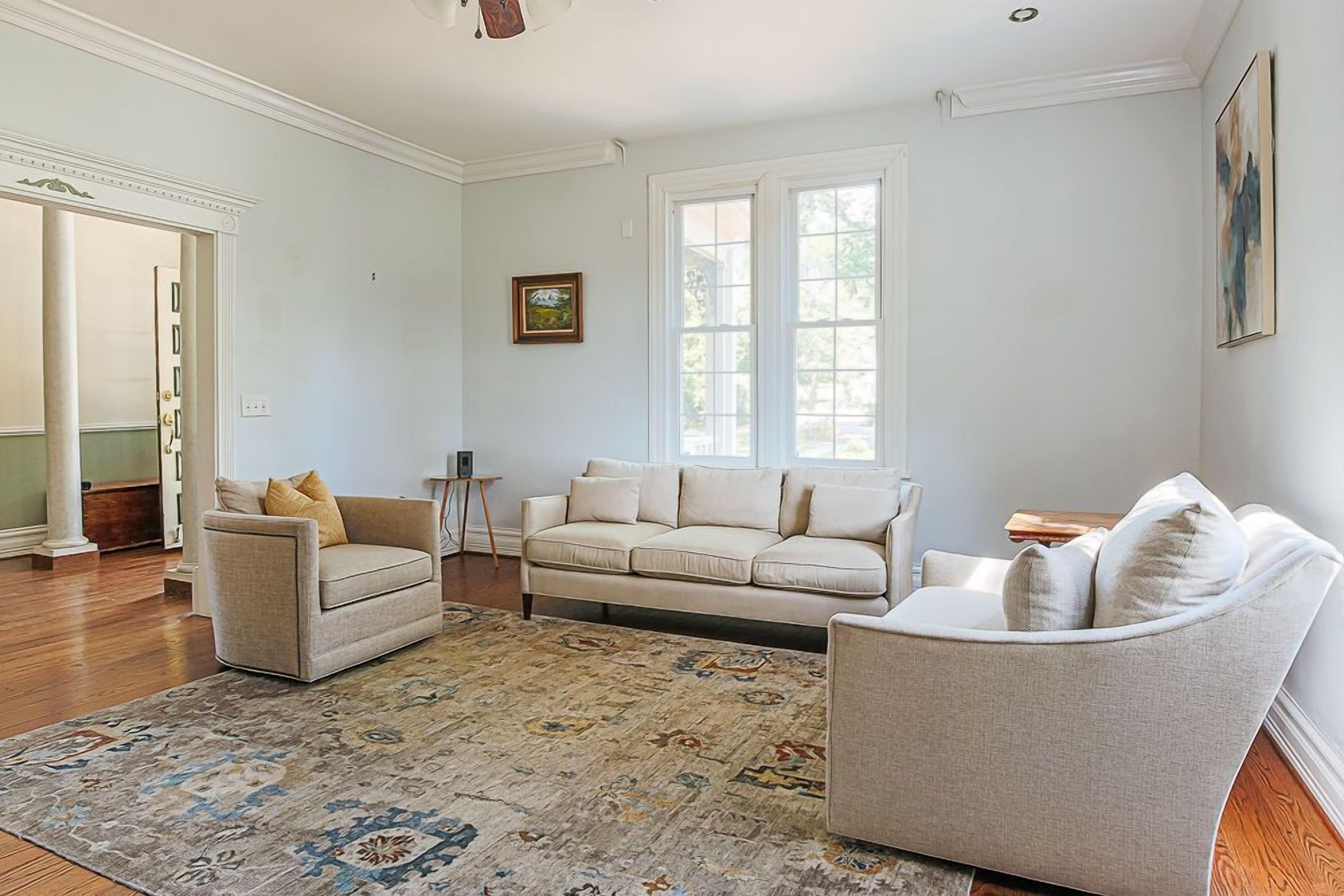 Ein geräumiges Wohnzimmer mit zwei Sofas, einem Couchtisch und einem gemusterten Teppich.