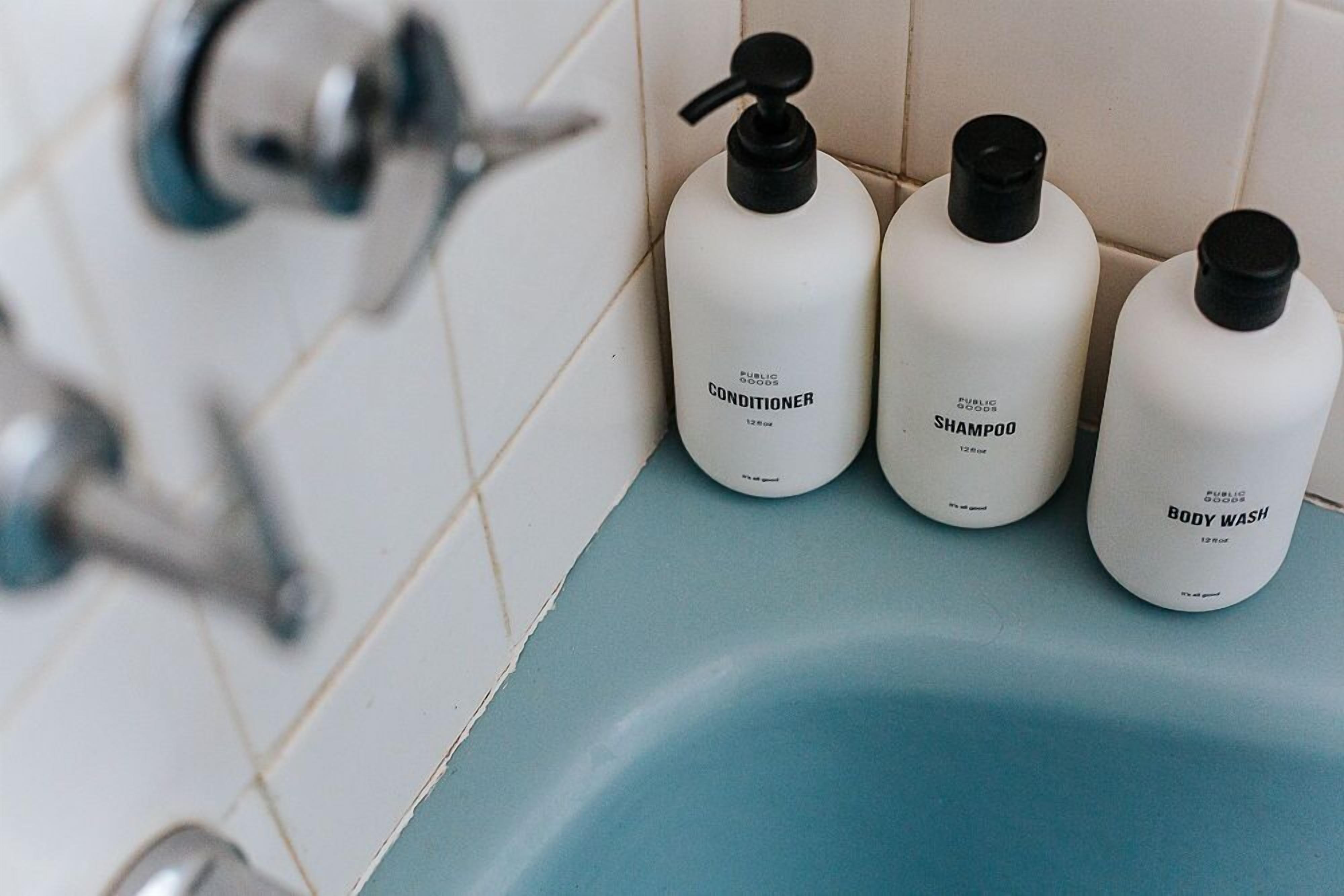 Trois bouteilles de produits d’hygiène courants sont posées sur le comptoir d’une salle de bain.