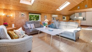 Ein gemütliches Blockhaus-Interieur mit Holzbalkendecke, Essbereich und Küche.