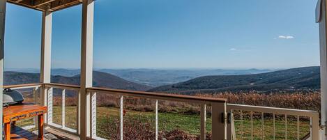 A covered outdoor area with a view of rolling hills.