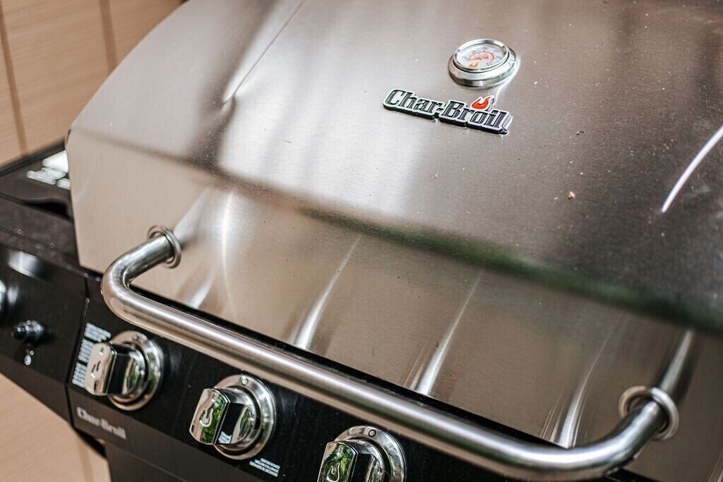 Ein Char-Broil Grill mit einem Edelstahl Deckel, Bedienelementen und einem Griff.