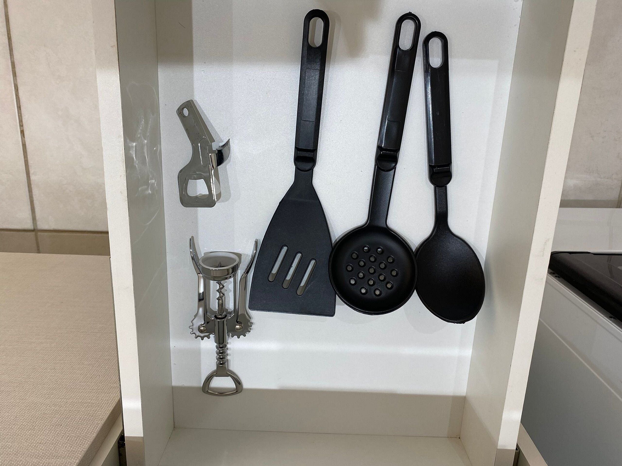 Un portalápices de cocina con una espátula, una cuchara y un abrelatas.