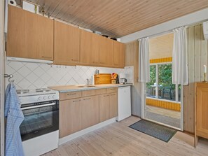 Una cocina funcional con armarios de madera, estufa y lavamanos.