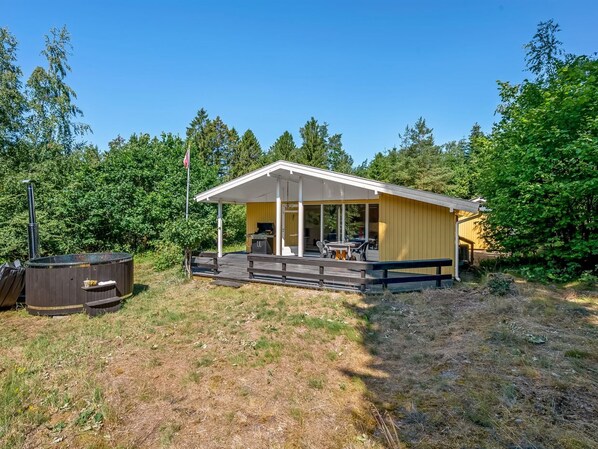 A single-story cabin with a covered porch, a hot tub, and a flagpole. - "Ursula" - 7km from the sea by Interhome (Ebeltoft)