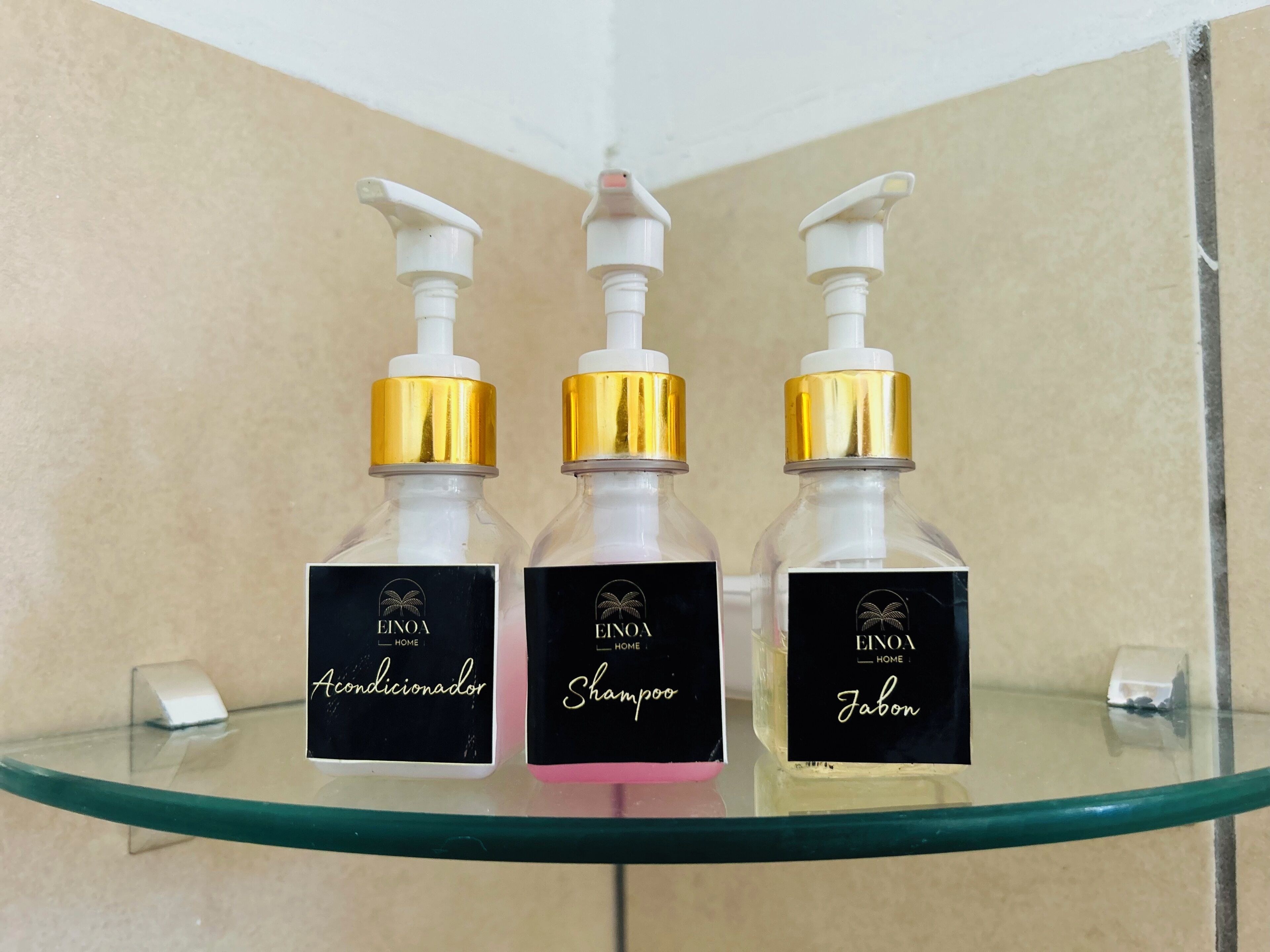 Trois bouteilles de produits d’entretien Einoa sont posées sur une étagère en verre.