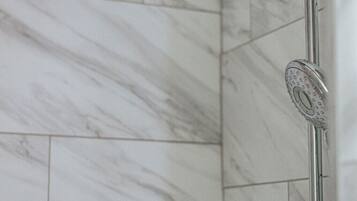 Eine Dusche mit Handbrause und Armaturen an der Wand.