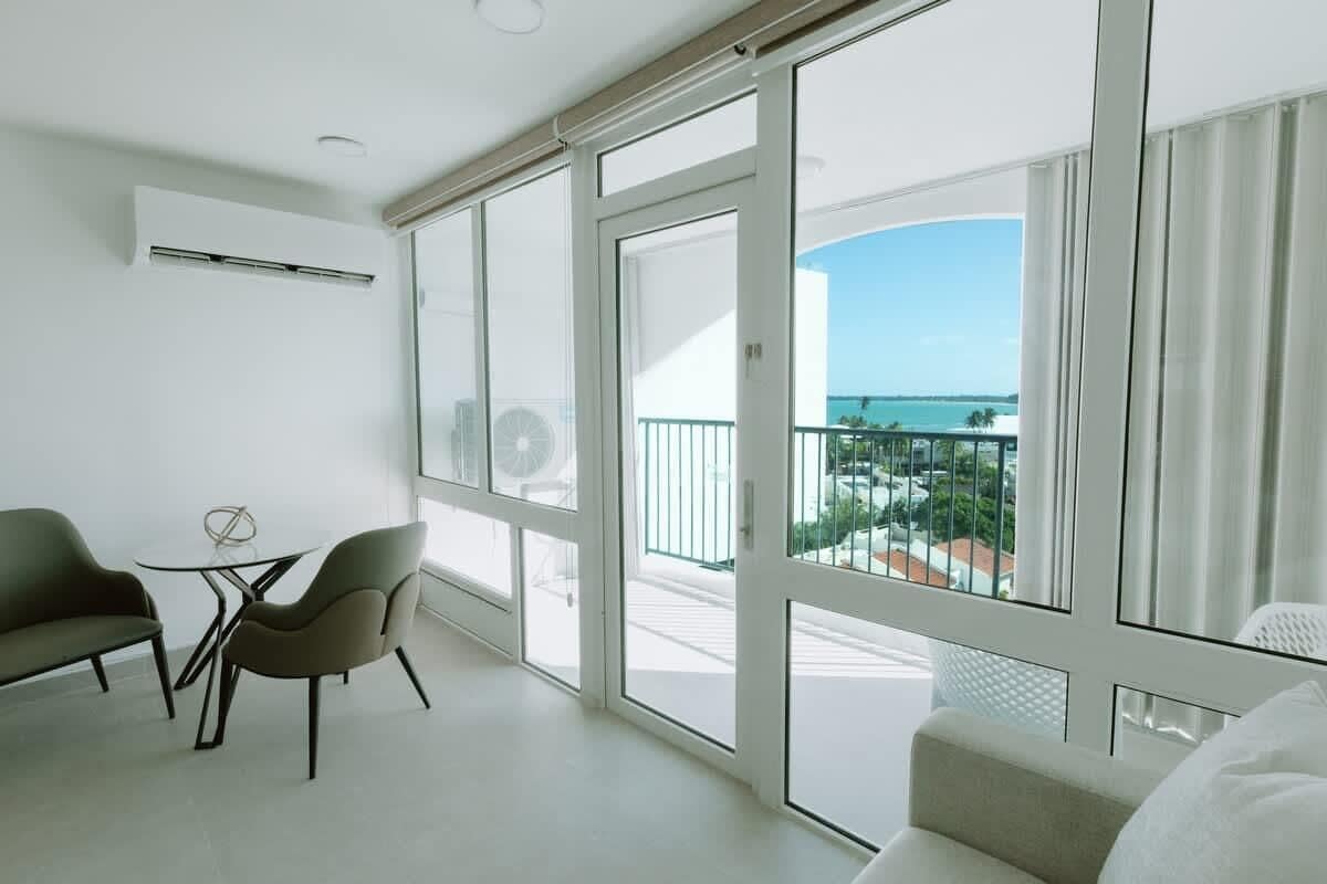 Ein Balkon mit Meerblick, einer Couch und zwei Sesseln.