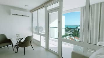 Ein Balkon mit Meerblick, einer Couch und zwei Sesseln.