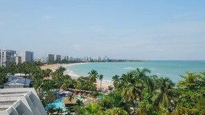 Un resort con piscina, palmeras y vista al mar.