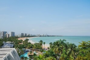 Un resort con piscina, palmeras y vista al mar.