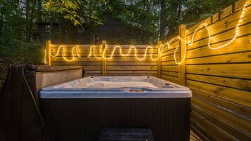 Ein Whirlpool mit einer Holterrasse und einer Lichterkette.