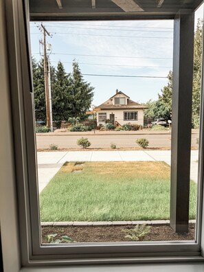 A residential house with a front yard, a sidewalk, and a street.