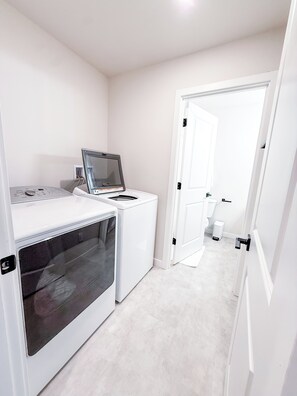 A laundry room with a washing machine, dryer, and a control panel.