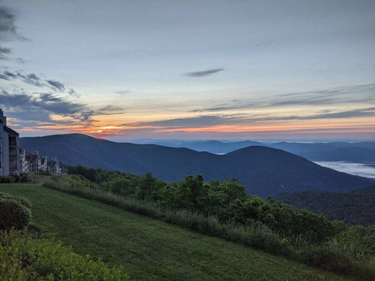 A view of a mountainous landscape with a building on the left.