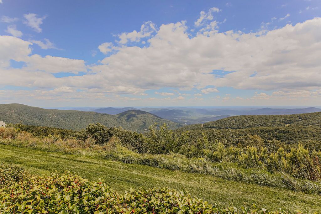 A panoramic view of a mountainous landscape with rolling hills and a clear sky.