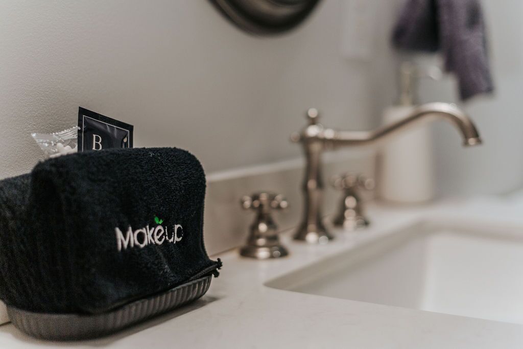 A bathroom sink with a black towel and a sign labeled 'B' on it.