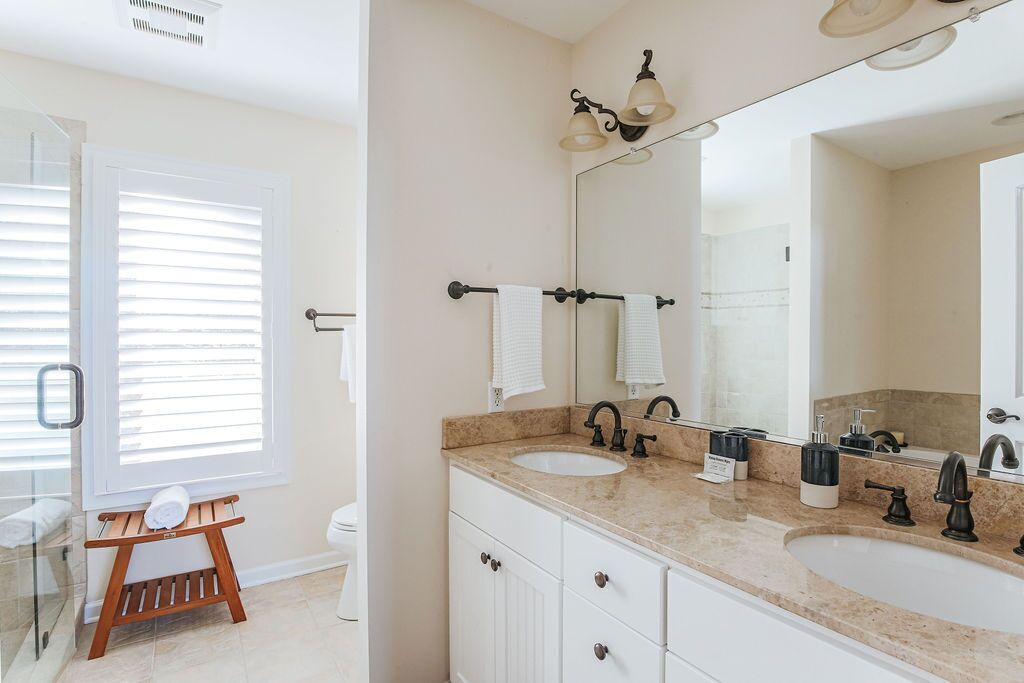 A bathroom with two sinks, a large mirror, and a towel rack.
