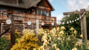 A wooden house with a balcony and a garden with yellow flowers. - Ridgeview Retreat (Staunton)