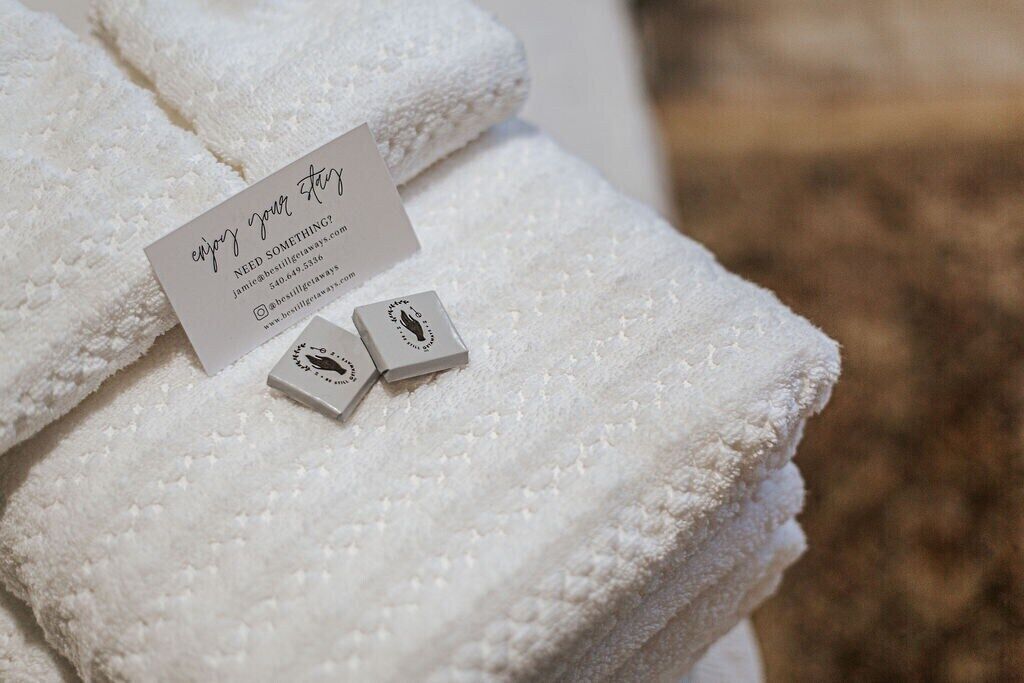 A white towel with a card and two small boxes on it.
