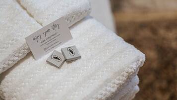 A white towel with a card and two small boxes on it.