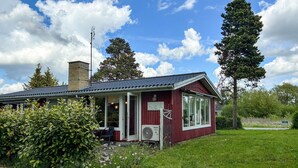 Un bâtiment rouge avec un porche, une cheminée et une enseigne indiquant qu’il s’agit d’un restaurant.