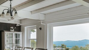 Un comedor con mesa, sillas, un armario y vistas al exterior.
