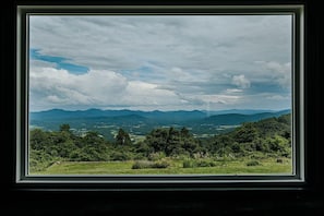 Vista enmarcada de un paisaje montañoso con árboles y cielo despejado.