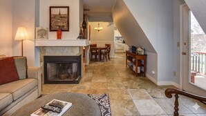 A living room with a fireplace, a ceiling fan, and a dining area with a table and chairs. - The Terrace 2 BR near the courthouse square with a King bed in the master BR (Prescott)