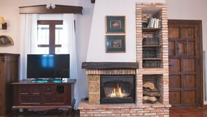 A living room with a fireplace, a television, and a bookshelf.
