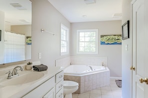 A bathroom with a bathtub, sink, and toilet. - The Pond Cabin (Linden)