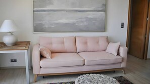 Ein modernes Wohnzimmer mit einer Couch, einer Lampe und einem großen abstrakten Gemälde an der Wand.