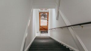 A staircase leading to a door with a motorcycle visible through the window. - The Social Loft (Staunton)