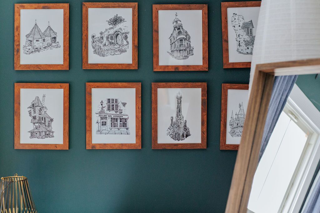 Eine Wand mit gerahmten, schwarz-weißen Architekturzeichnungen.