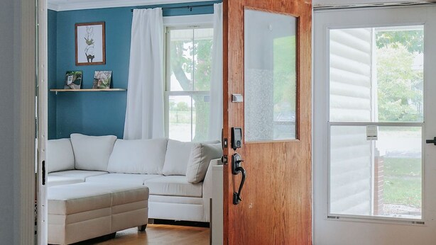 A modern living room with a white sofa, a wooden door, and a ceiling fan. - The Wayne Shire (Waynesboro)