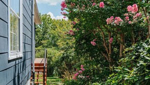 Ein Haus mit einer Holzterrasse und einer Treppe, die zu einer Veranda führt.
