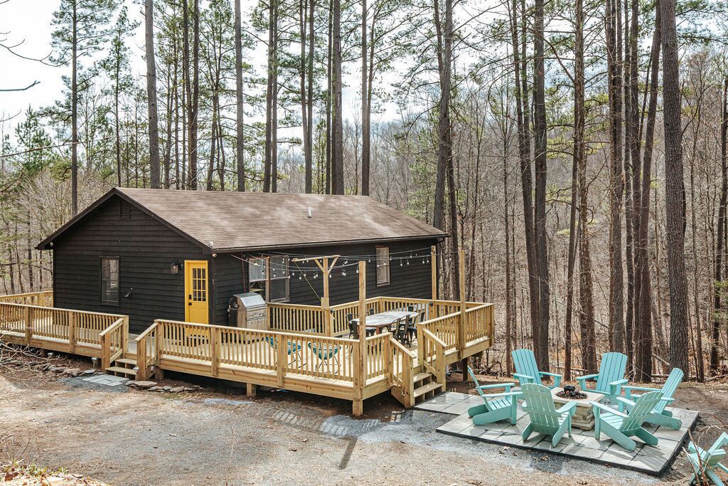 Une cabane dotée d’une terrasse, d’un espace salon extérieur et d’un foyer.