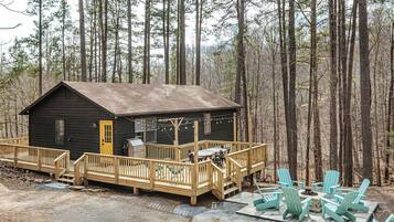 Une cabane dotée d’une terrasse, d’un espace salon extérieur et d’un foyer.