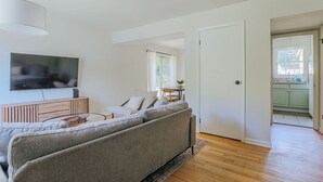 Una sala de estar moderna con un sofá gris, un televisor de pantalla plana y un mueble de madera.