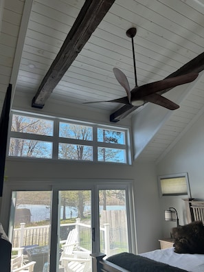 Une pièce dotée d’un ventilateur de plafond, de grandes fenêtres et offrant une vue sur l’extérieur.
