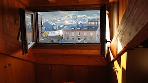 Una habitación de madera con ventana que da a una ciudad.