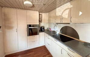 A kitchen with wooden cabinets, a black countertop, and a stove. - Beautiful home in Haderslev with WiFi (Haderslev)
