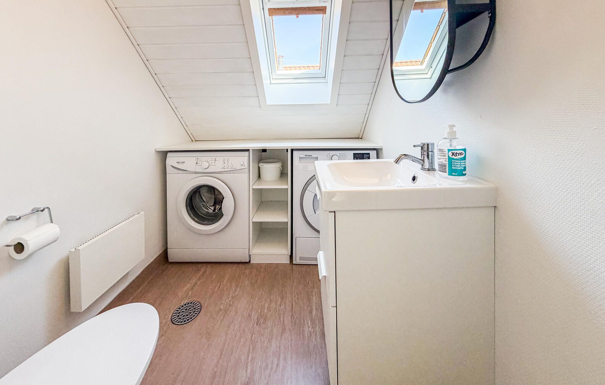 A compact laundry room with a washing machine, dryer, and sink.
