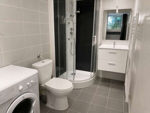 A bathroom with a washing machine, toilet, glass-enclosed shower, and a sink with a mirror. - A cozy vacation home with a terrace (PYLA SUR MER)