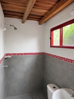 A bathroom with a shower, toilet, and a window with a red frame. - Premium Cabin, 1 King Bed, Mountain View (Floridablanca Santandee)