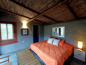 A bedroom with a bed, a nightstand, a window, and a door. - Premium Cabin, 1 King Bed, Mountain View (Floridablanca Santandee)
